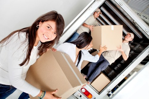 Professional movers carrying furniture into a Bromley home